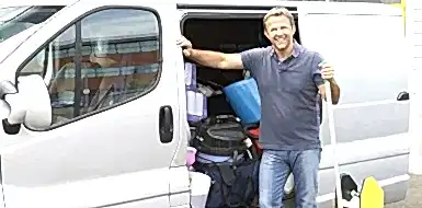 Person stands by a van full of cleaning supplies.