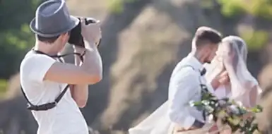 Wedding photographer taking a picture of a bride and groom.