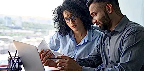 Two coworkers reading a document