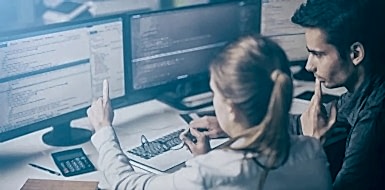 Two cybersecurity consultants examining client software code.