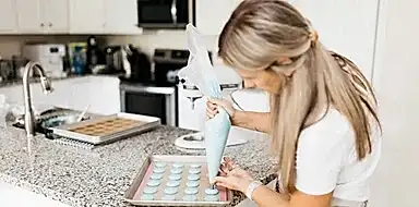 A home baker prepares frosting for a client order 
