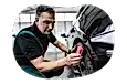 Auto shop employee detailing a car.