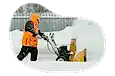 Snow removal professional plowing a sidewalk.