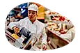 Deli employee slicing meat.
