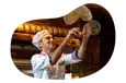 A chef tosses pizza dough in the air.