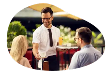 Waiter serving customers a meal in a restaurant.