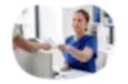 Patient handing paperwork to staff in a medical office.