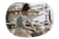 Pottery artisan crafting a clay pot in a shop.