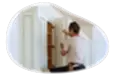 A contractor installing a kitchen cabinet.