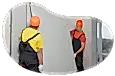 Contractors installing drywall into a building.