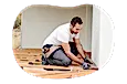 Contractor installing floorboards in a home.