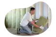 A contractor installs wall insulation in a client's home.