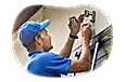 A contractor installs an exterior light over a garage.