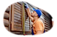 A contractor measuring the shutters on a log cabin.