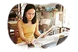 Hobby store employee taking inventory of art supplies on a computer.