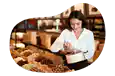 Candy store employee stocking front case in a shop.
