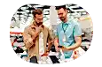 Electronics store employee showing smartphones on display to a customer.