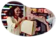 A cashier hands a paper bag to a customer at a convenience store.