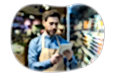 The owner of a general store checks a list of products on a tablet.
