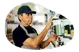 A business owner examines a can of paint in their paint and wallpaper store.