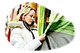A customer examines curtains in a window shade and curtain store.