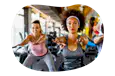 Fitness instructor guiding a class through stretches in a gym.