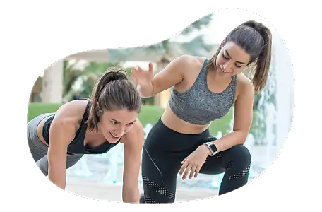 Personal trainer helping a client in a fitness center.