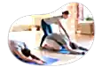 Yoga instructor guiding a person through a stretch at a studio.