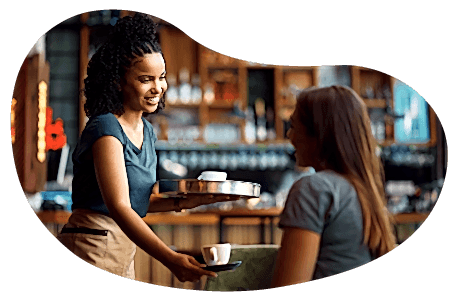 A cafe owner gives a customer their coffee order
